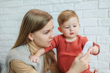 Anne ve çocuk vücut ısısını elektrikli termometreyle ölçüyorlar. Temas olmayan termometre