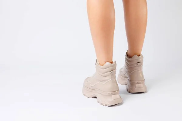 穿着米黄色皮鞋的女腿从最新的系列白色背景女腿到2022年春天由生态皮鞋制成的时髦鞋子 — 图库照片