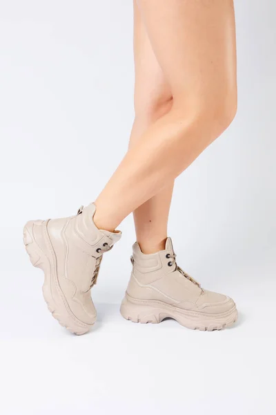 穿着米黄色皮鞋的女腿从最新的系列白色背景女腿到2022年春天由生态皮鞋制成的时髦鞋子 — 图库照片