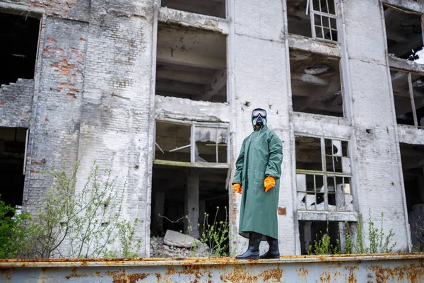 A dosimetrist scientist in protective clothing and a gas mask checks the level of radioactive radiation in the danger zone. Environmental pollution, disaster