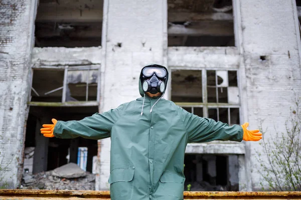 A dosimetrist scientist in protective clothing and a gas mask checks the level of radioactive radiation in the danger zone. Environmental pollution, disaster