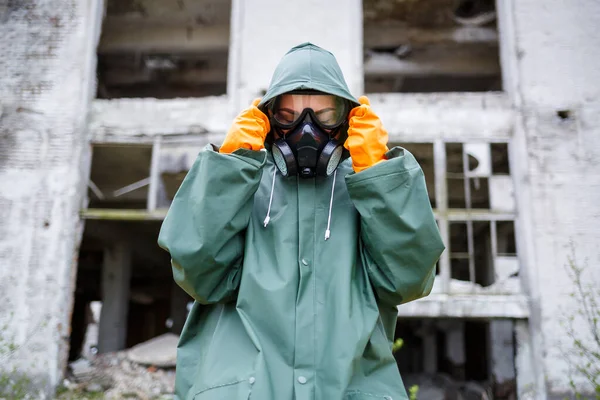 A dosimetrist scientist in protective clothing and a gas mask checks the level of radioactive radiation in the danger zone. Environmental pollution, disaster