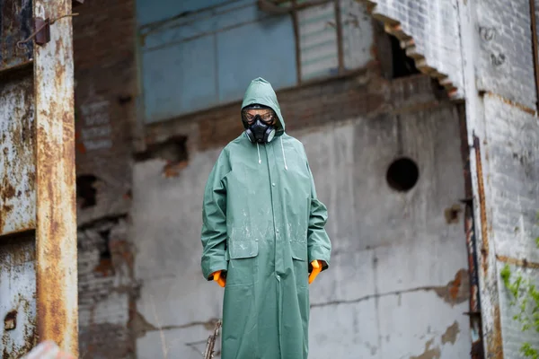 A man with a protective mask and protective clothing examines the danger zone. Ecological catastrophe. Dangerous toxic zone