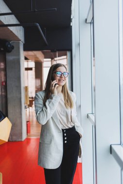 Boş zamanlarında bir kafede tek başına oturan, cep telefonuyla arayan genç ve çekici bir kadın, kafede dinlenirken tatlı bir gülümsemeyle cep telefonuyla konuşan çekici bir kadın.