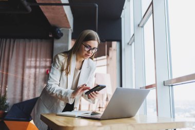 Boş zamanlarında bir kafede tek başına oturan, cep telefonuyla arayan genç ve çekici bir kadın, kafede dinlenirken tatlı bir gülümsemeyle cep telefonuyla konuşan çekici bir kadın.