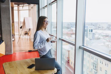 Avrupalı iş kadını çalışırken dizüstü bilgisayar kullanıyor. Modern başarılı kadın kavramı. Kahveli güzel, güzel, gülümseyen bir kadın kafede oturuyor. Ofisin içini aç
