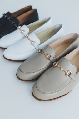 Yerde bir sürü kadın ayakkabısı, farklı deri ayakkabılar. Yeni kadın ayakkabıları yere saçılmış.