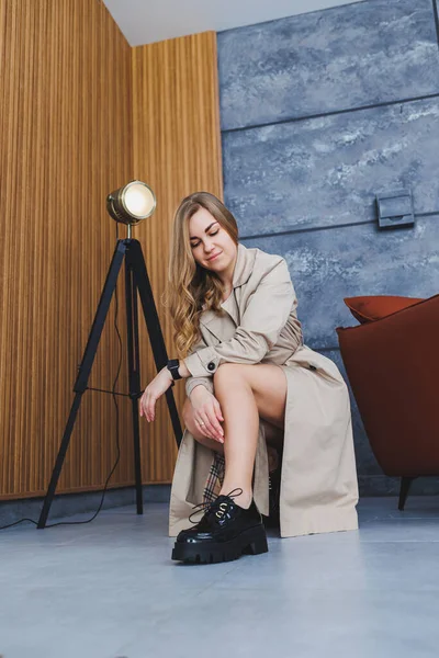 Jonge Mooie Vrouw Zit Vloer Een Beige Lente Regenjas Moderne — Stockfoto