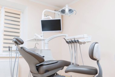 Hastaları kabul etmek için yeni bir koltuğu olan modern şık parlak dişçi ofisi. seçici odak