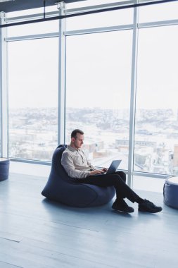 Başarılı bir işadamı çalışan bir kafede oturur ve önemli bir proje üzerinde çalışır. İşadamı dizüstü bilgisayarda yazıyor. Kafede dizüstü bilgisayar kullanan bir iş adamı