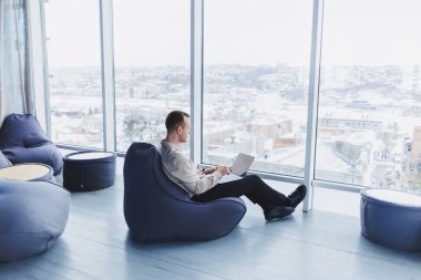 Başarılı bir işadamı çalışan bir kafede oturur ve önemli bir proje üzerinde çalışır. İşadamı dizüstü bilgisayarda yazıyor. Kafede dizüstü bilgisayar kullanan bir iş adamı