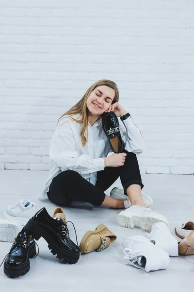 Una Mujer Joven Sienta Suelo Entre Los Zapatos Elige Zapatos — Foto de Stock
