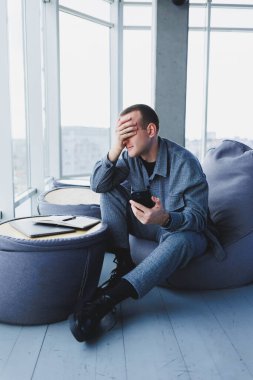 Bir kafede oturan yakışıklı Avrupalı genç bir işadamı cep telefonuyla oturur ve not defterine notlar alır. Şık bir takım elbise giyip halka açık bir kafede dizüstü bilgisayarla oturmak.