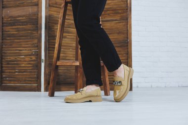 Siyah kotlu, şık deri ayakkabılı kadın bacaklarının yakın çekimi. Yeni ayakkabılı, modaya uygun bir kadın. Modern sezonluk şık ayakkabı koleksiyonu. Kadın modası.