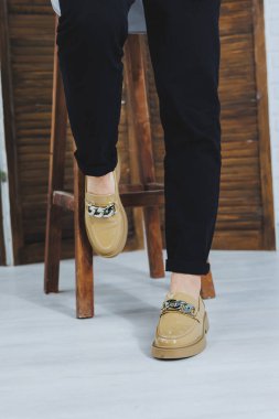 Siyah kotlu, şık deri ayakkabılı kadın bacaklarının yakın çekimi. Yeni ayakkabılı, modaya uygun bir kadın. Modern sezonluk şık ayakkabı koleksiyonu. Kadın modası.