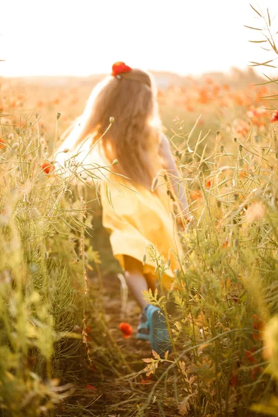 Menina Vestido Amarelo Corre Flores Papoula Vermelhas Fundo Grama Verde — Fotografia de Stock