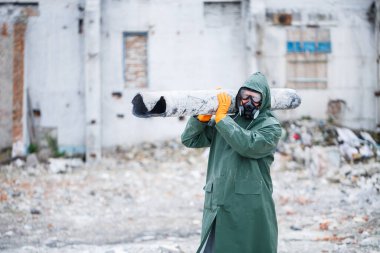 Koruyucu maskeli ve koruyucu giysili bir adam tehlike bölgesini keşfeder. Ekolojik bir felaket. seçici odak