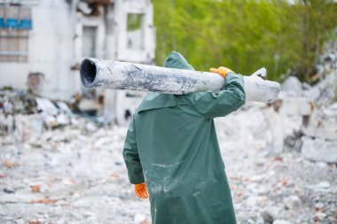 Koruyucu maskeli ve koruyucu giysili bir adam tehlike bölgesini keşfeder. Ekolojik bir felaket. seçici odak