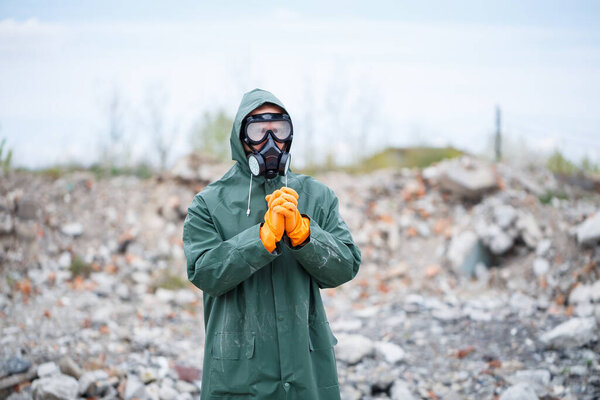 A man in a protective mask and protective clothing explores the danger zone. Ecological catastrophe. selective focus