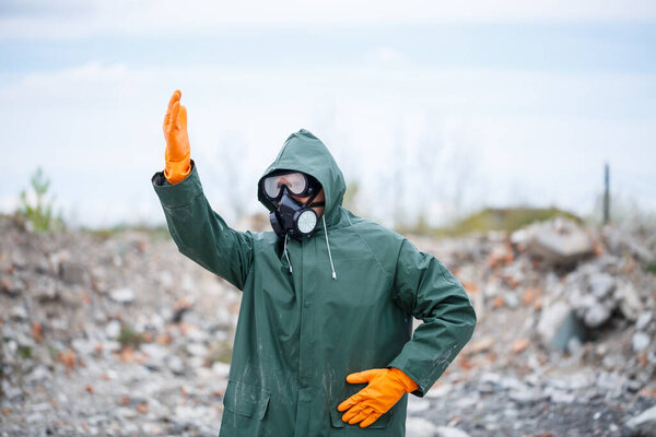 A man in a protective mask and protective clothing explores the danger zone. Ecological catastrophe. selective focus