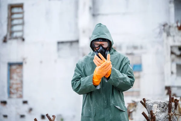 Un homme portant un masque de protection et des vêtements de protection explore une zone radioactive dangereuse. — Photo