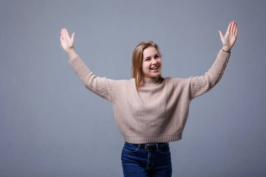 Neşeli genç bir kadının portresi, izole edilmiş gri duvar arkaplanı. Olumlu insani duygular, yüz ifadeleri. Reklam konsepti, müşteri memnuniyeti