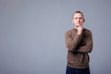 Neşeli genç yakışıklı bir adamın portresi, erkek, izole edilmiş gri duvar arka planı. Olumlu insani duygular, yüz ifadeleri. Reklam konsepti, müşteri memnuniyeti