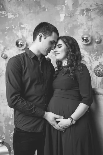 形象的丈夫站在和抱着怀孕的妻子的手的腹部 女孩和可爱的英俊男人抱着肚子在家里 爱的夫妻 父母身份的概念 小宝宝洗澡 全家福 — 图库照片