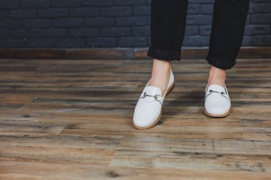 Siyah pantolon ve deri bej mokasen giyen kadın bacakları. Kadın deri ayakkabılarının yeni bahar-yaz koleksiyonu 2022