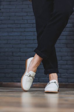 Siyah pantolon ve deri bej mokasen giyen kadın bacakları. Kadın deri ayakkabılarının yeni bahar-yaz koleksiyonu 2022