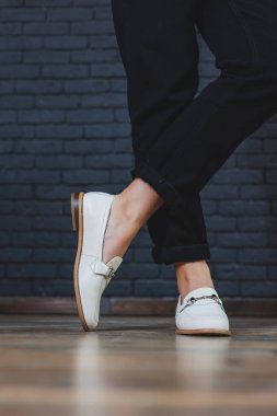 Siyah pantolon ve deri bej mokasen giyen kadın bacakları. Kadın deri ayakkabılarının yeni bahar-yaz koleksiyonu 2022