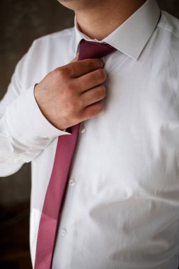 Genç erkek işadamı toplantıdan önce bir gömlek ve şık bir takım elbise giyer.