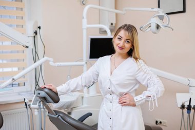 Dişçi dişçi ofisinde. Beyaz önlüklü dişçi kadın. Diş hekimliği