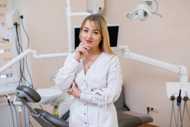 Dişçi dişçi ofisinde. Beyaz önlüklü dişçi kadın. Diş hekimliği