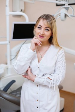 Dişçi dişçi ofisinde. Beyaz önlüklü dişçi kadın. Diş hekimliği