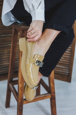 Siyah kotlu, şık deri ayakkabılı kadın bacaklarının yakın çekimi. Yeni ayakkabılı, modaya uygun bir kadın. Modern sezonluk şık ayakkabı koleksiyonu. Kadın modası.