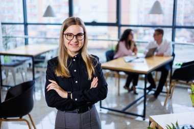 Genç kadın işadamı. İş takımı organizasyonu ve yatırım planları, iş yerinde şema, grafik ve iş aksesuarları bulunan yeni bir başlangıç projesi üzerinde çalışırken.