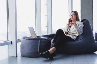 Gülümseyen kadın yönetici internet uygulaması üzerinden teslimat servisini kontrol etmek için cep telefonu kullanıyor kahve dükkanındaki 4G kablosuz ağına bağlanıyor, cep telefonuyla mesajlaşan neşeli serbest yazar