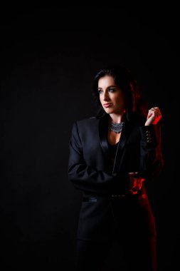 Avrupalı görünümlü koyu renk saçlı güzel bir kadının portresi. Siyah bir ceket giymişti. Siyah arkaplanda izole