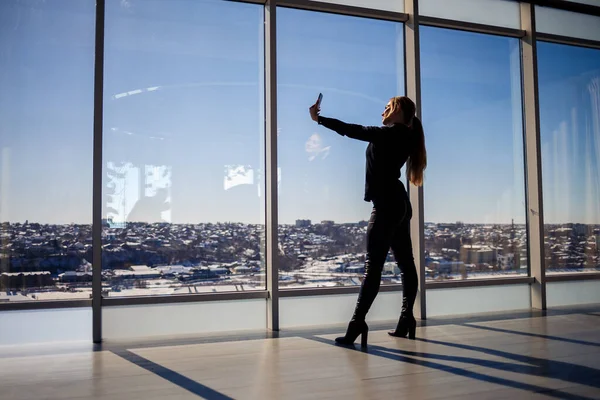 Una Hermosa Chica Toma Una Selfie Teléfono Contra Fondo Ventanas — Foto de Stock