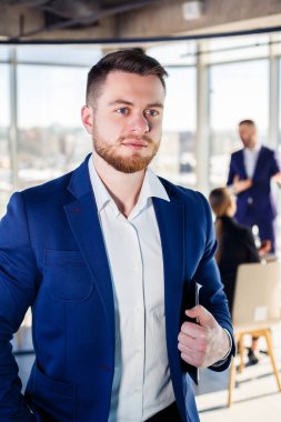 Başarılı bir erkek akıl hocası, yönetmen, ofiste takım elbiseli bir iş adamı. Çalışma günü konsepti. Ön planda patronla takım toplantısı var.