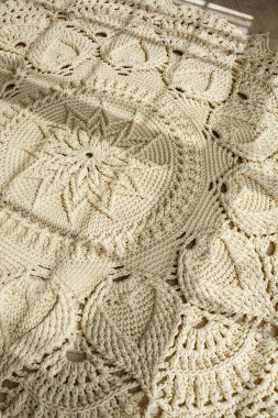 El yapımı kalın ipliklerden örülmüş ev yapımı halı: bej ipliklerden yapılmış el yapımı bir halı yerde yatıyor, güneş onun üzerinde parlıyor