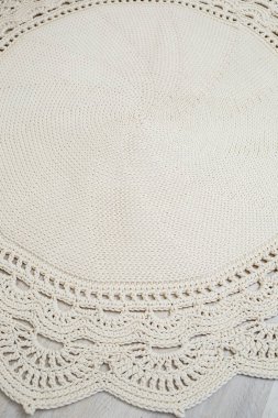 Doğal ipliklerden, döşemeden, doğal pamuktan örülmüş el yapımı halı. Bej el yapımı halı. Örülmüş dekoratif öge