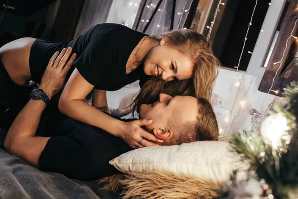 新年の間にベッドの上で抱擁で若いカップルの写真を閉じます 抱擁とクリスマスのためのキス 若いカップルロマンチックな新年の時間 — ストック写真
