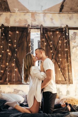 Romantik çift yeni yıldan önce evde çelenklerle vakit geçiriyorlar. Genç kadın ve yakışıklı erkek sarılır, öpüşür. Noel zamanı. Yeni yılda mutlu bir çift