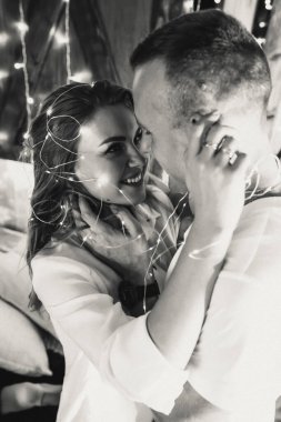 Tutkulu romantik çift yeni yıldan önce evde çelenklerle vakit geçiriyor. Genç kadın ve yakışıklı erkek sarılır, öpüşür. Noel zamanı.