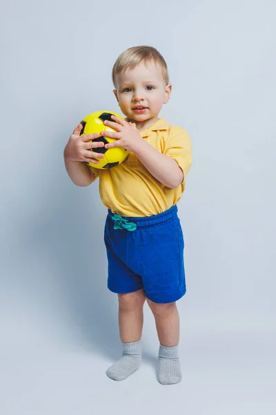 Niño Pequeño Con Una Pelota Fútbol Sus Manos Sobre Fondo —  Fotos de Stock