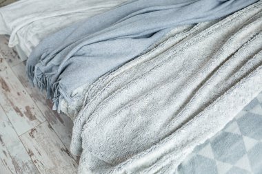 Evin içi için gri sıcak battaniyeler yatağın üzerinde yatıyor.