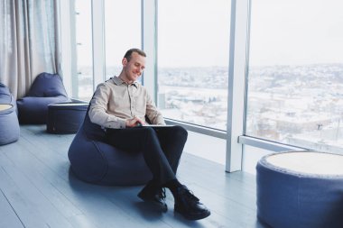 Bir iş adamı modern bir ofis çalışma alanında otururken müşterileriyle telefonla iletişim kurar. Odaklanmış iş adamı modern bir çalışma alanında tek başına oturur..