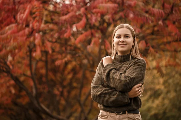緑のニットセーターとオレンジの木と秋の公園で軽いジーンズで美しいブロンドのウクライナの女性 黄金の秋 — ストック写真